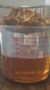Orange and tangerine peels being strained as golden glycerin drips into a measuring cup